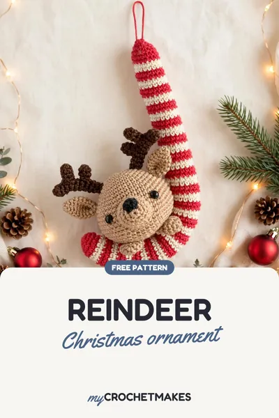 A crocheted reindeer ornament tucked into a red and white striped candy cane, hanging on a Christmas tree